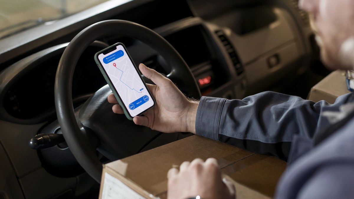 A consumer holding a smartphone while reviewing online shopping orders