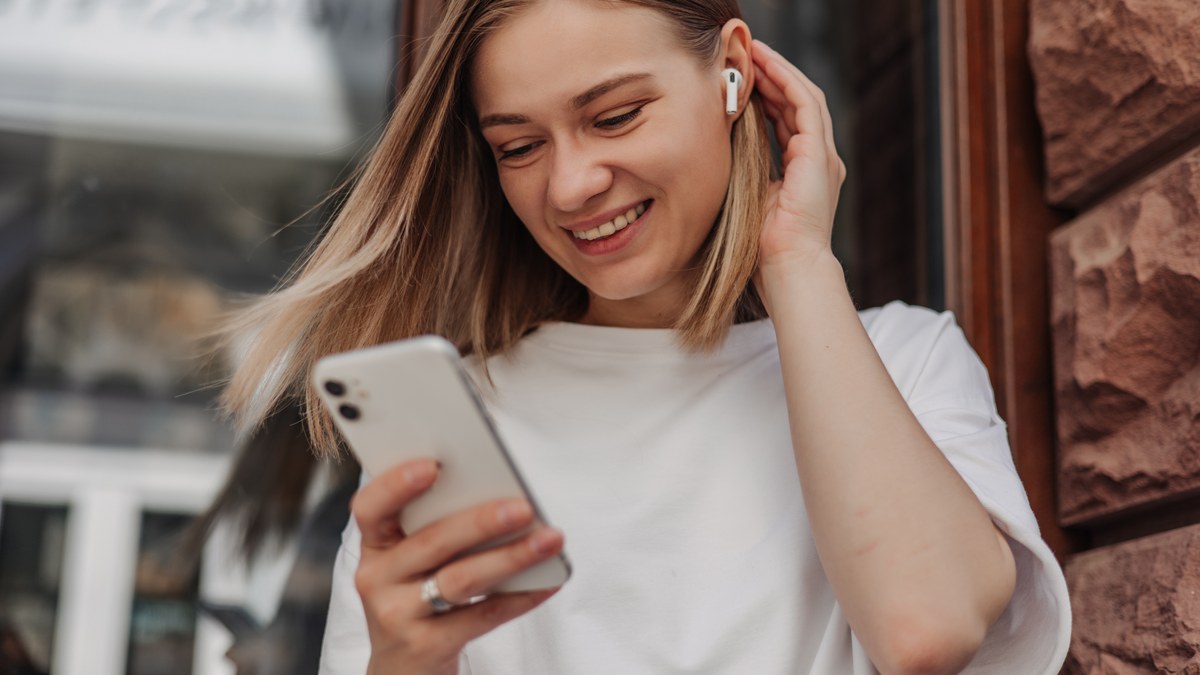 A listener wearing headphones enjoying music streamed directly on a mobile phone