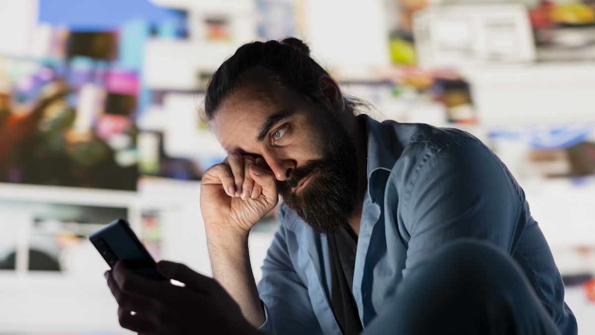 Frustrated content creator looking at an overloaded and cluttered smartphone bio link page