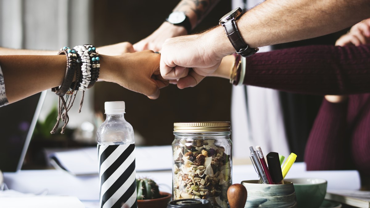Two creative partners shaking hands during a business collaboration meeting in a modern office