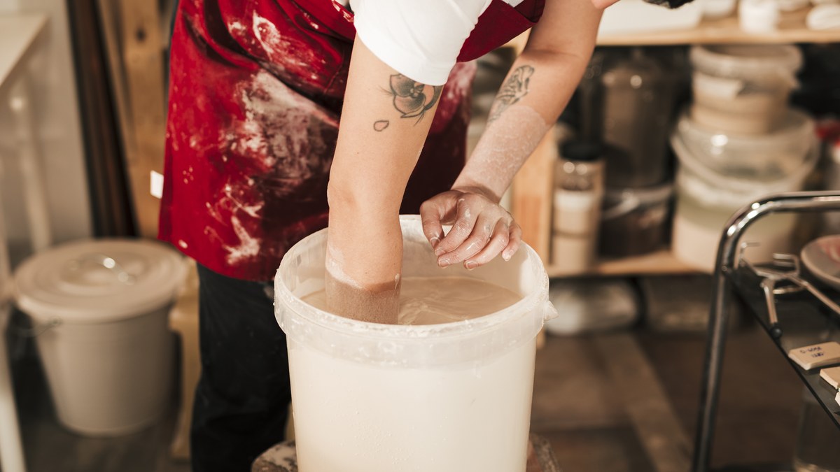 Artisan ceramic maker preparing handmade pottery in craft workshop