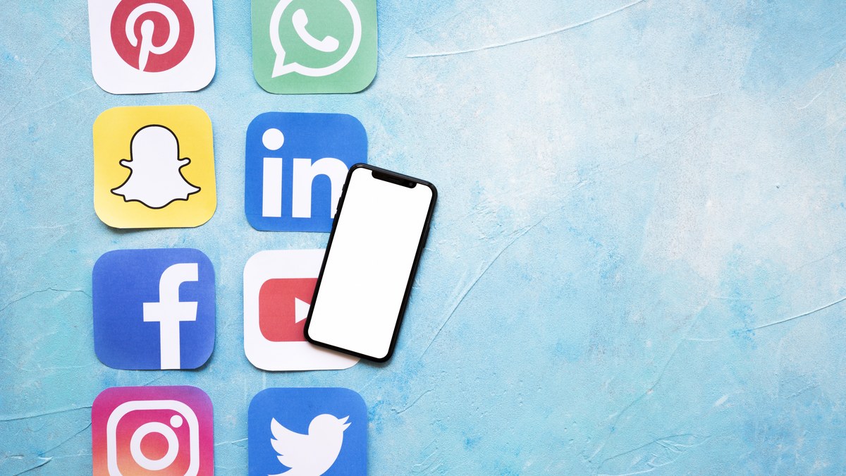 Smartphone held in hand displaying an Instagram profile grid with bio and follower count