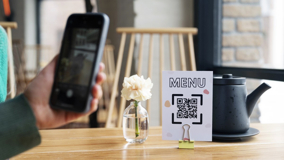 Cozy modern cafe table with a ceramic coffee cup and a printed dynamic QR code menu tent