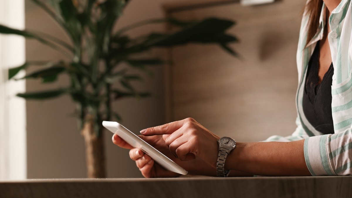 Boutique luxury resort patio overlooking the ocean with a smartphone showing an interactive hotel concierge guide