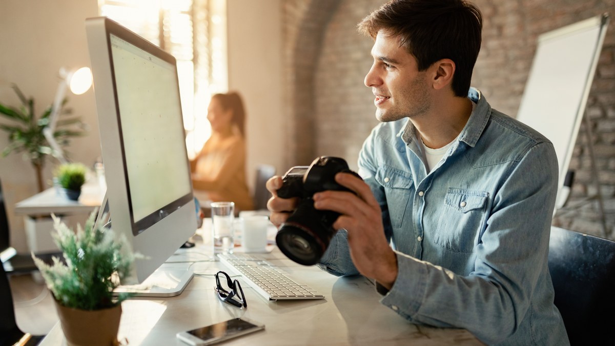 Professional photographer reviewing digital photo gallery on laptop and camera in studio