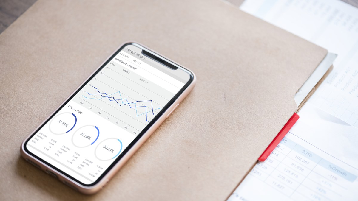 Digital marketer analyzing social media marketing analytics dashboard and click-through rates on laptop and smartphone