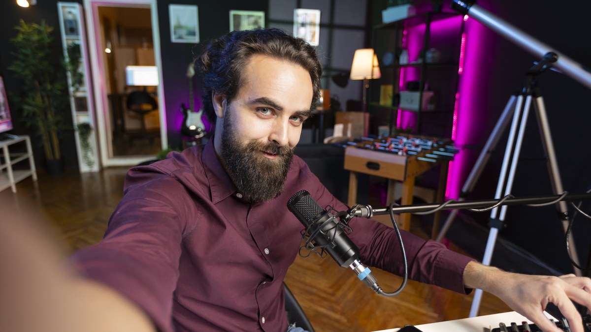 A podcast host speaking into a professional studio microphone recording an audio episode