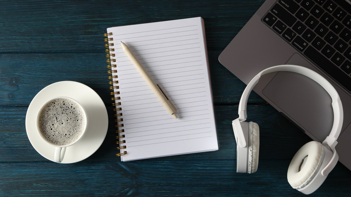 Podcast studio setup with professional microphone headphones and planning checklist notebook