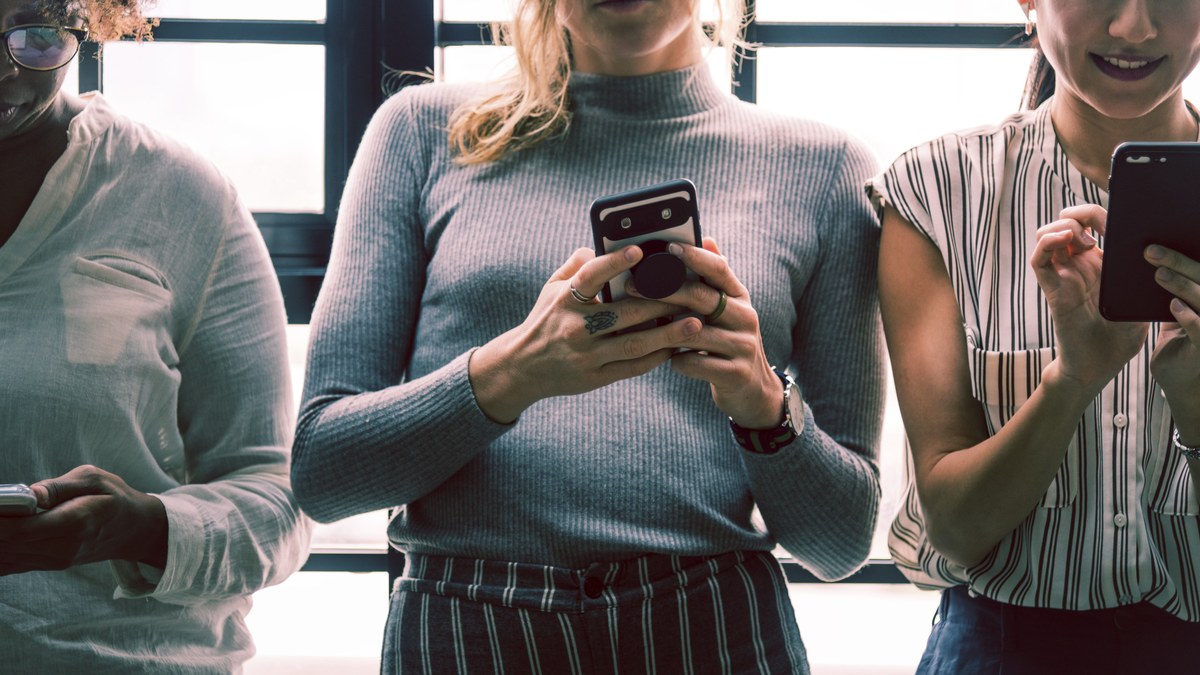Diverse group of young people using smartphones to message in community channels