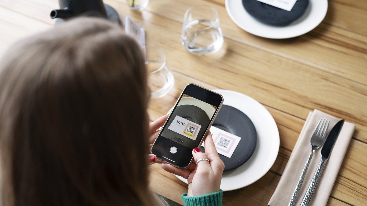Restaurant table setting with elegant wooden QR code block next to cocktail and dinner menu
