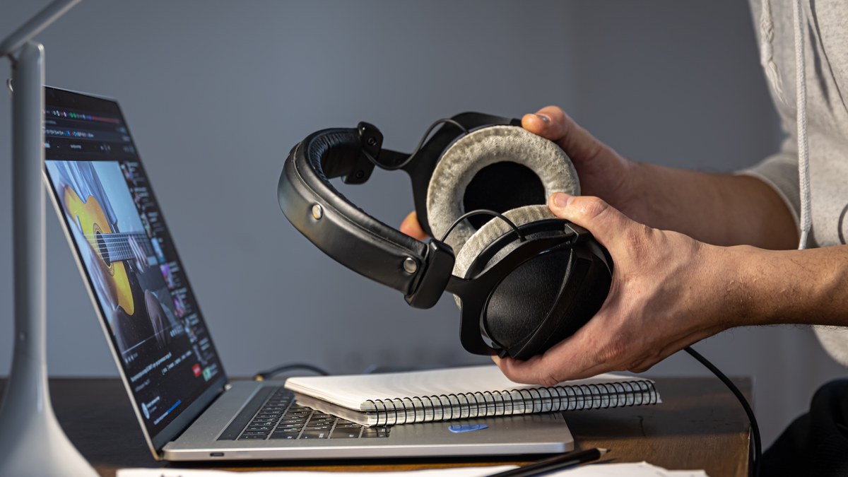 A music producer working on audio waveforms in a studio at night