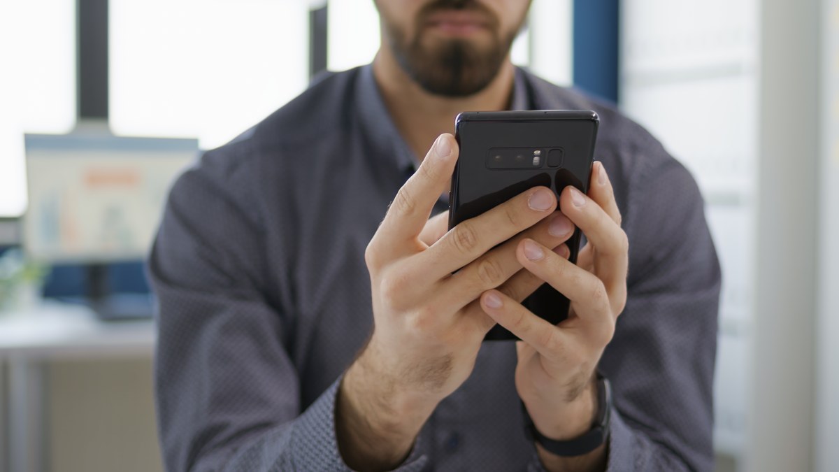 A professional reviewing smartphone messaging application screens and troubleshooting connectivity