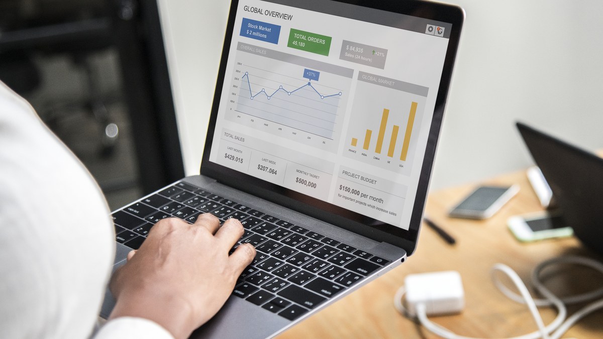 Business professional analyzing digital marketing dashboard metrics and traffic graphs on laptop screen