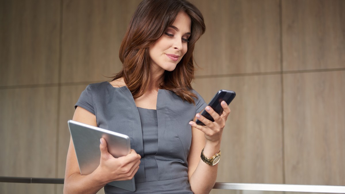Business professional replying to customer inquiries on WhatsApp using a smartphone in an office